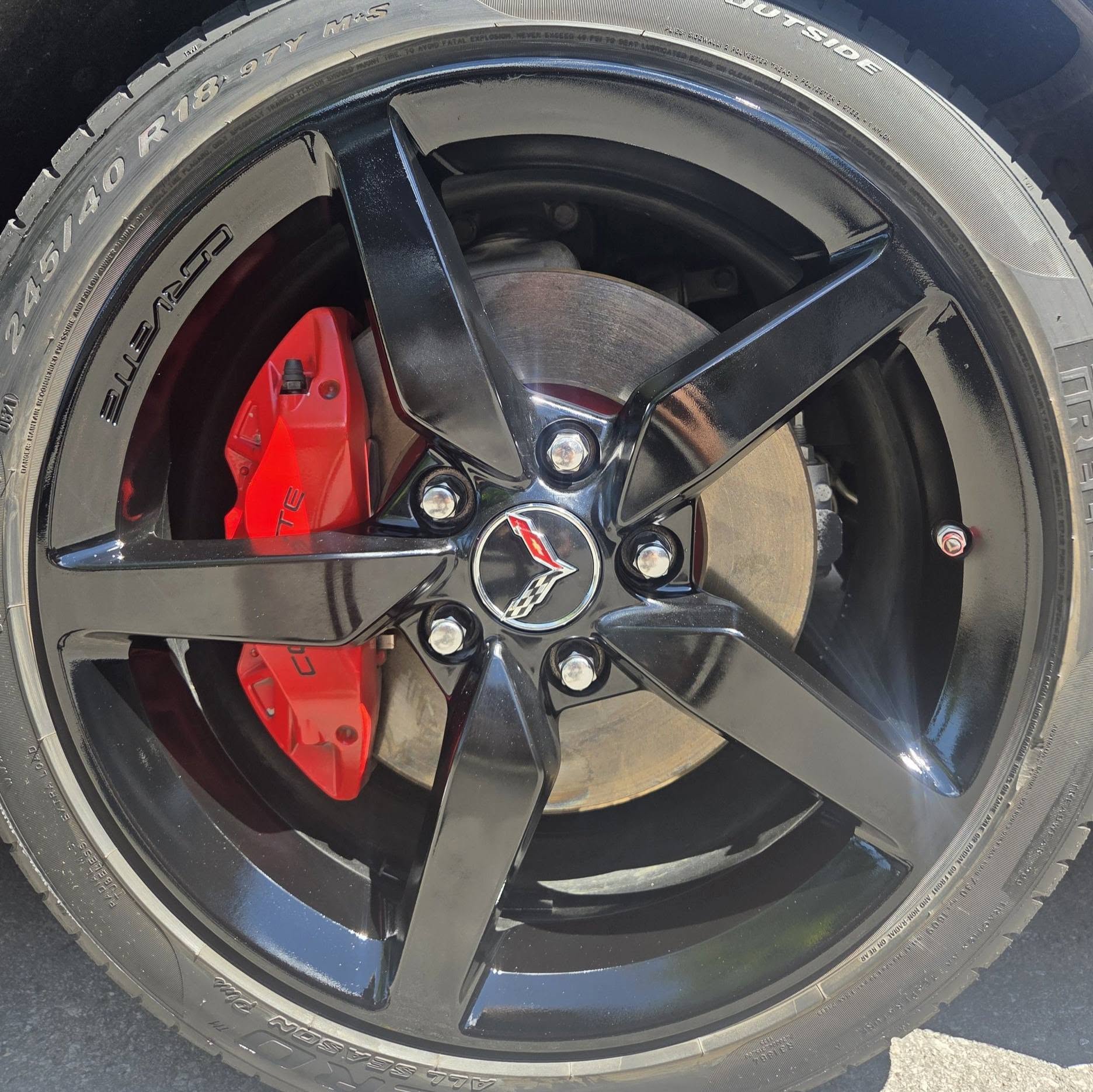 Restored gloss-black Corvette wheel after refinishing